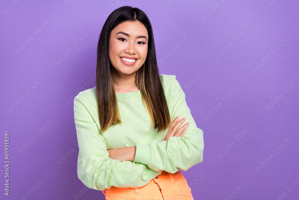 Photo of confident cheerful lady wear green sweatshirt arms crossed empty space isolated purple color background Photo of confident cheerful lady wear green sweatshirt arms crossed empty space isolated purple color background