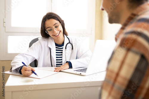 Smiling doctor showing document to patient photo