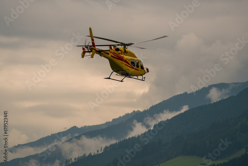 a emergency help with a helicopter in the mountains at a cloudy summer day
