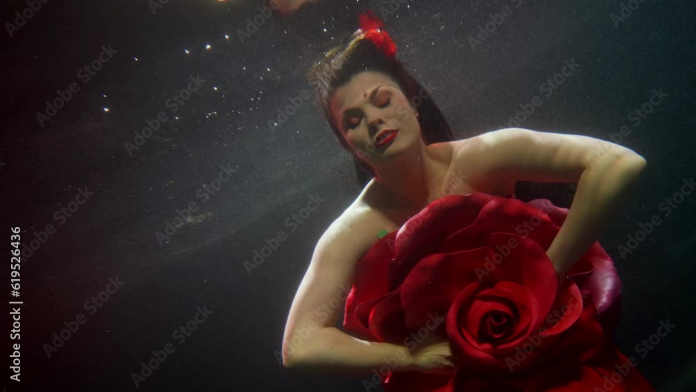 amazing beautiful woman with red lips in gown of rose swimming underwater, fantasy and fairytale amazing beautiful woman with red lips in gown of rose swimming underwater, fantasy and fairytale