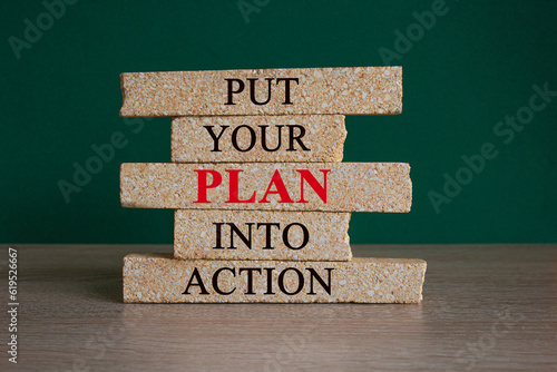 Brick blocks with words Put your plan into action. Beautiful green background, wooden table. Copy space. Businessman icon, light bulb. Business, plan into action concept.