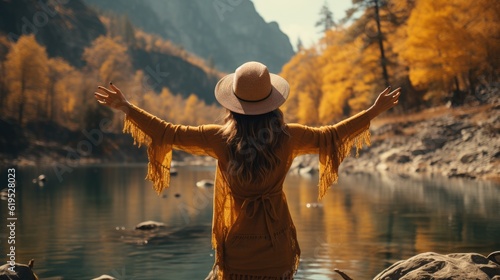 Woman with her arms raised on nature near the river.