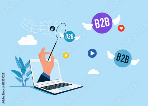 Businessman  through the laptop trying to catch flying social media network ads and internet. SMM, Internet notification. B2B word in speech bubble. B2B marketing. 