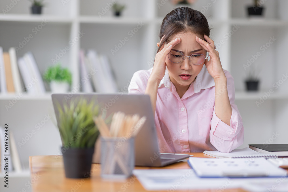 Obraz premium Portrait of tired young business Asian woman wear glasses work with documents tax laptop computer in office. Sad, unhappy, Worried, Depression, or employee life stress concept