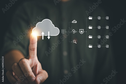 The businessman's finger points to the cloud icon, signifying the seamless connection and access to data on a digital network. Embrace the concept of a global business community. photo