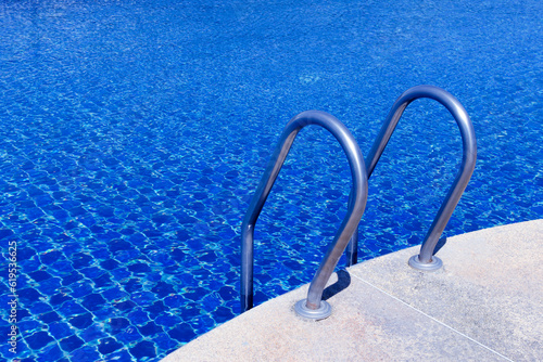 Fotografi Swimming pool with stair at hotel close up, Ladder stainless handrails for descent into swimming pool