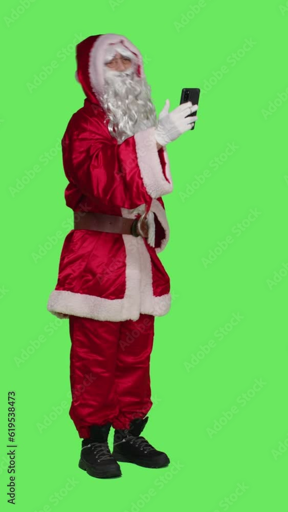Vertical video Side view of saint nick uses videocall meeting online, talking to someone on remote teleconference chat. Young man dressed as santa claus chatting on videoconference, christmas eve Vertical video Side view of saint nick uses videocall meeting online, talking to someone on remote teleconference chat. Young man dressed as santa claus chatting on videoconference, christmas eve