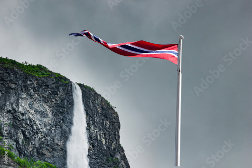 Norwegische Nationalflagge vor einem Wassefall