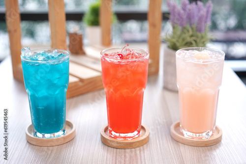 Refreshing cold beverage for summer on ice. Colorful summer drink in tall glass with wood saucer for hot day and party.