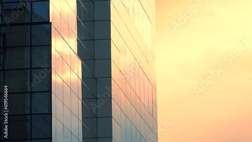 Office builiding, exterior view on the sky background with colorful yellow and orange clouds, public urban scene, panning, close up, time lapse, long exposure, multiple exposure, perspective. ProResHQ photo