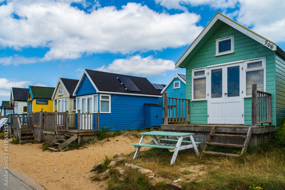 Hengistbury Head, UK - July 1st 2023: Beach huts on Mudeford Sandbank. Hengistbury Head, UK - July 1st 2023: Beach huts on Mudeford Sandbank.