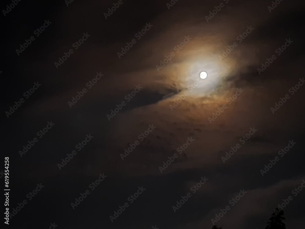 amazing cloudy sky and the moon behind it , July,3,2023 : Rampur Uttar Pradesh India.