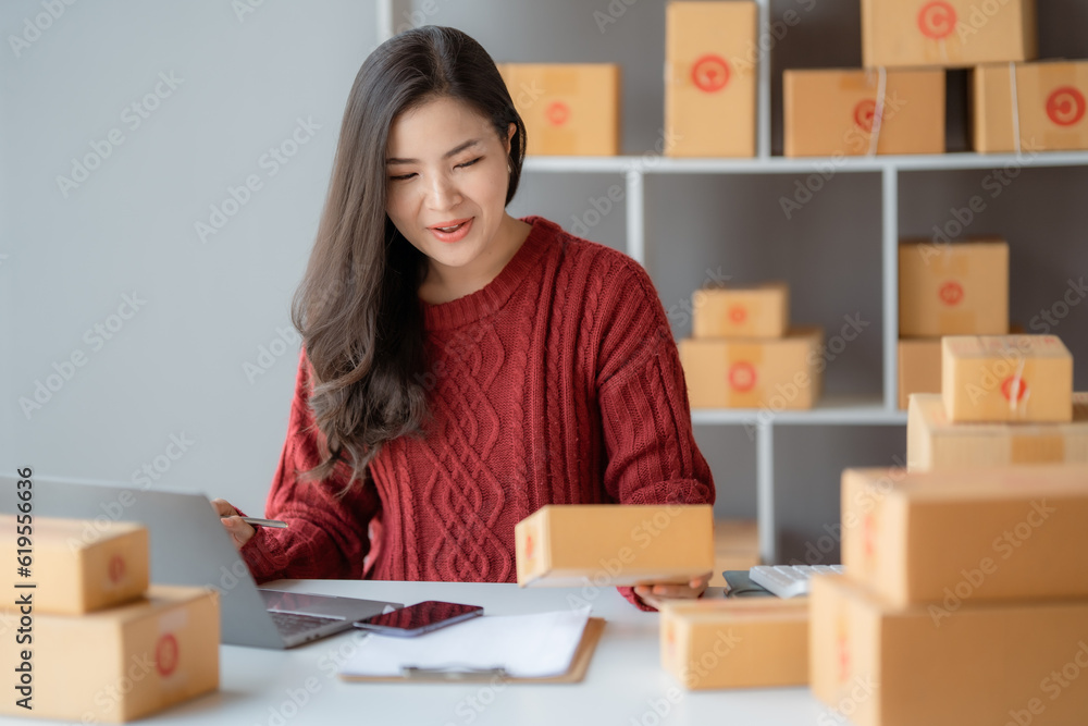 Starting Small business entrepreneur SME freelance, Portrait young woman working at home office, BOX, smartphone, laptop, online, marketing, packaging, delivery, b2b, SME, e-commerce concept.. Starting Small business entrepreneur SME freelance, Portrait young woman working at home office, BOX, smartphone, laptop, online, marketing, packaging, delivery, b2b, SME, e-commerce concept..