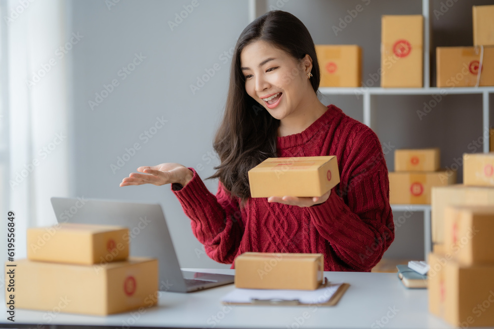 Starting Small business entrepreneur SME freelance, Portrait young woman working at home office, BOX, smartphone, laptop, online, marketing, packaging, delivery, b2b, SME, e-commerce concept..