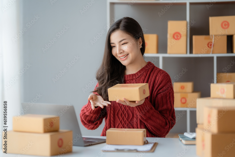 Starting Small business entrepreneur SME freelance, Portrait young woman working at home office, BOX, smartphone, laptop, online, marketing, packaging, delivery, b2b, SME, e-commerce concept.. Starting Small business entrepreneur SME freelance, Portrait young woman working at home office, BOX, smartphone, laptop, online, marketing, packaging, delivery, b2b, SME, e-commerce concept..