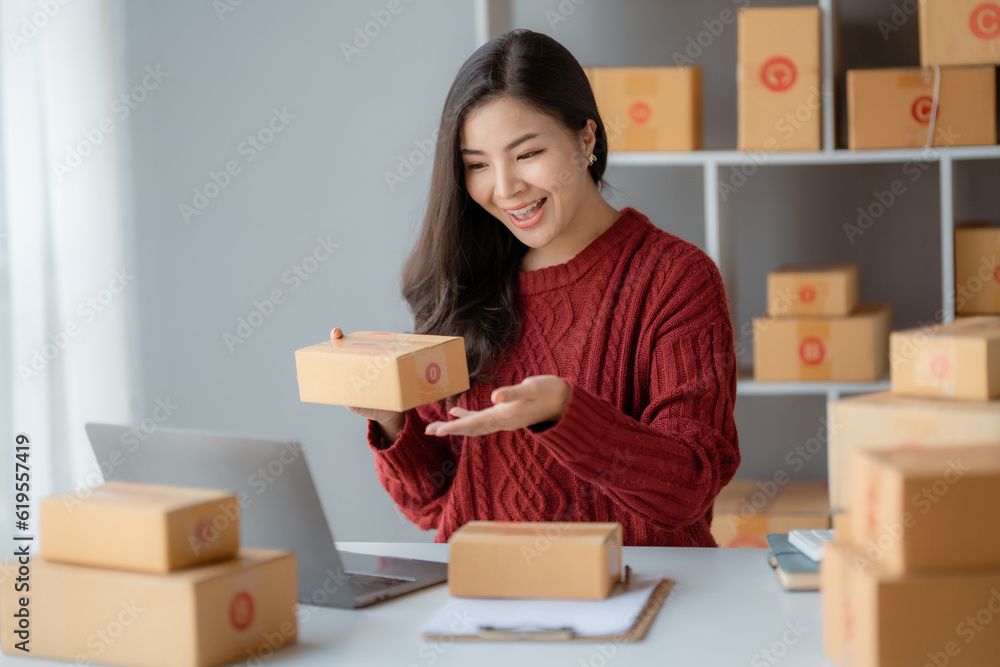 Starting Small business entrepreneur SME freelance, Portrait young woman working at home office, BOX, smartphone, laptop, online, marketing, packaging, delivery, b2b, SME, e-commerce concept.. Starting Small business entrepreneur SME freelance, Portrait young woman working at home office, BOX, smartphone, laptop, online, marketing, packaging, delivery, b2b, SME, e-commerce concept..