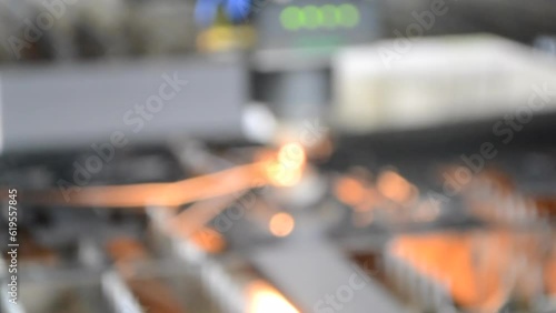 Wallpaper Mural Cutting a metal sheet with a laser in production. Sheet of metal lying on industrial equipment. Head Moving, sparks. Blurred background Torontodigital.ca