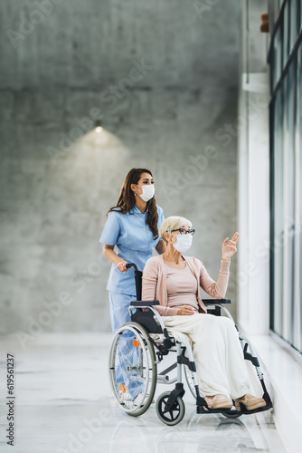 Young Caregiver Caring A Senior Female Wheelchair-Bound Patient