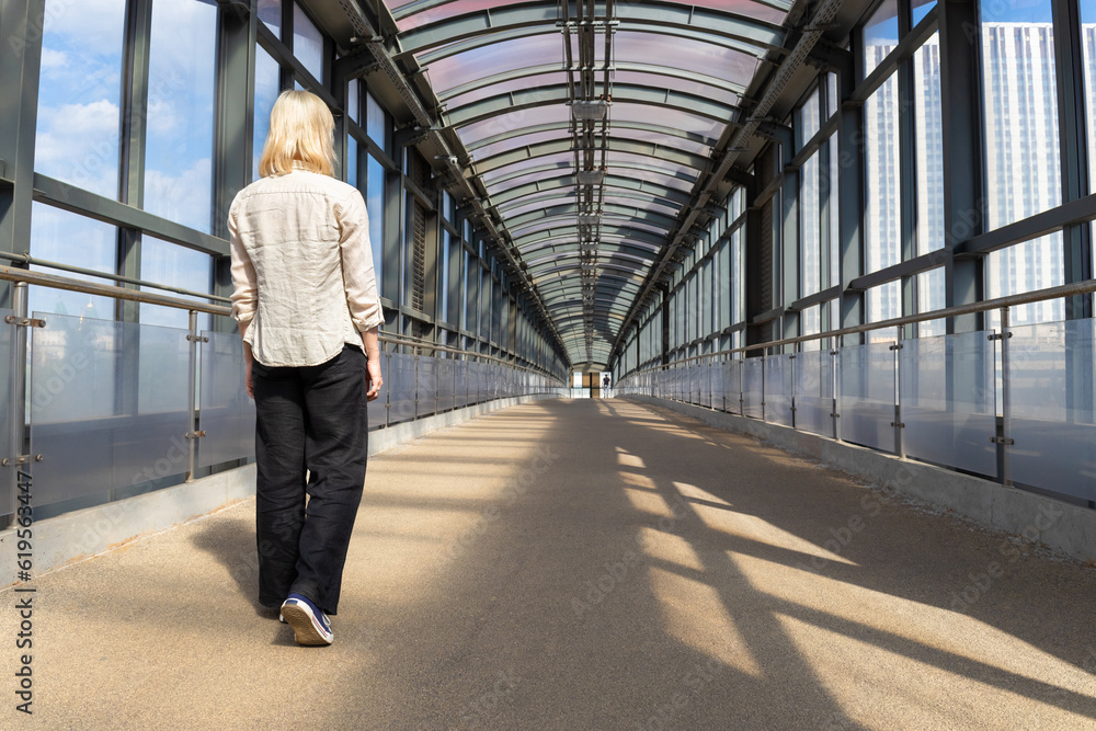 Moscow, Russia - June 18, 2023: a girl walks alone along an overpass. Moscow, Russia - June 18, 2023: a girl walks alone along an overpass.