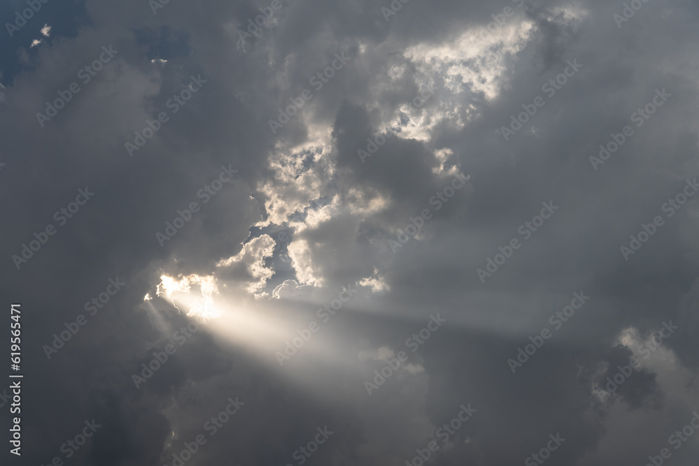dramatic sky clouds light beam streaks dark and moody background