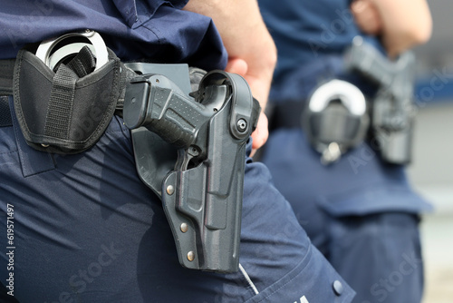  Kajdanki i pistolet w pokrowcu na pasie policjanta.  photo