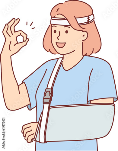 Woman with soft splint on injured arm shows OK gesture rejoices at availability of medical insurance