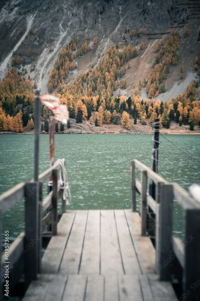 Scenic view from a wooden pier of the Sils Lake, in Switzerland, during a cloudy autumnal day