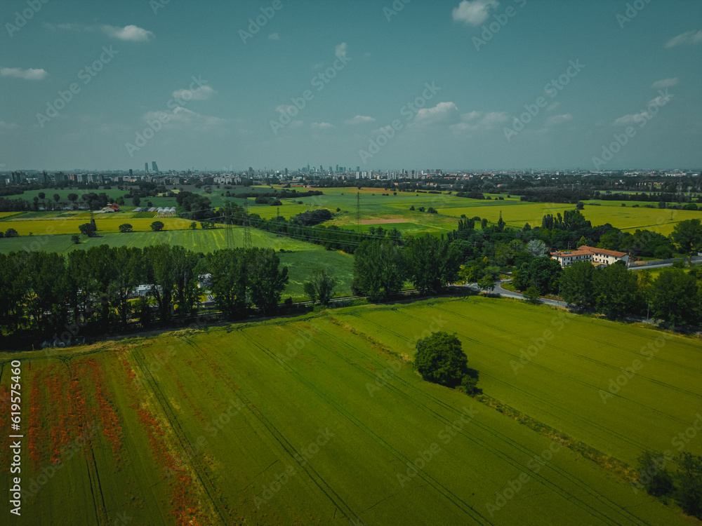 Aerial view of Poasco in Italy surrounded by fields and countryside. Milan, Lombardy Aerial photo. Top view of countryside and green fields. Country Life Concept. Aerial photography in the summer.  