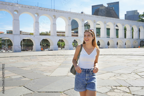Portrait of young tourist woman visiting Lapa neighborhood with Carioca Aqueduct (Arcos da Lapa) in Rio de Janeiro, Brazil photo