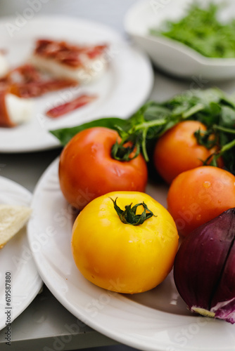 Fresh mozzarella, tomatoes, prosciutto and vegetable on the table