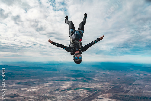 Vászonkép Woman skydiver in freefall alone over desert landscape