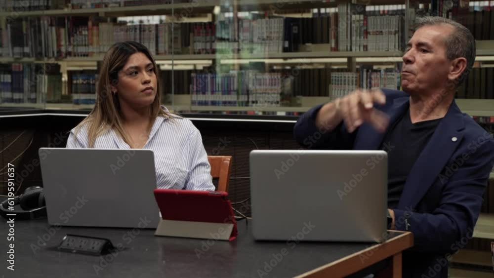 Young coworkers flirting and working in the office with their laptop Young coworkers flirting and working in the office with their laptop