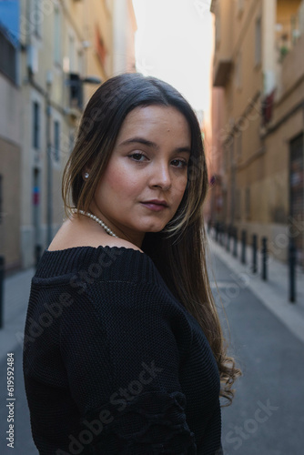 nice portrait of a long-haired pretty young woman looking over her shoulder with neutral but seductive expression © anuatmoralesfoto