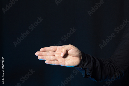 A man pointing with four fingers isolated on a dark background. Image with copy space. photo