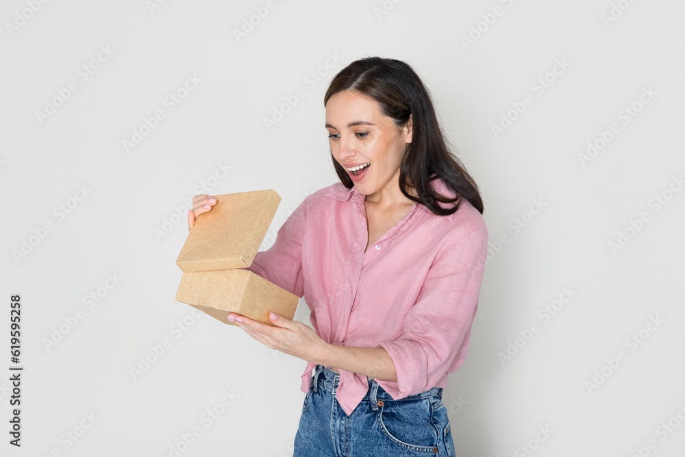 Emotional pretty millennial lady opening cardboard box Emotional pretty millennial lady opening cardboard box