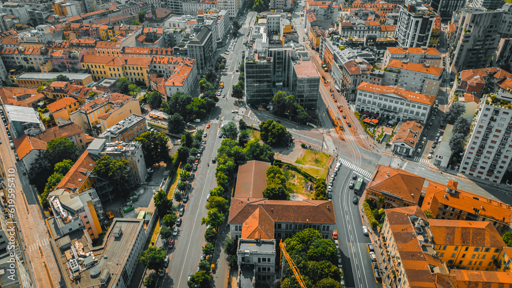 Fototapeta premium Aerial view of Milan downtown building roofs. Bird's eye view from helicopter of cityscape metropolis infrastructure