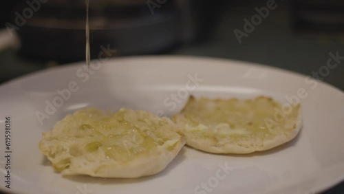 Dripping honey onto warm cooked English muffins
