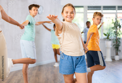 Positive preteen children learning to dance waltz in pairs in choreography class
