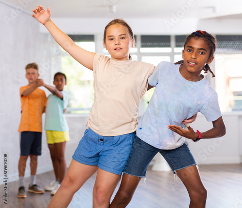 Fototapeta Naklejka Na Ścianę i Meble -  Active young multinational children enjoying of partner dance in in dance studio