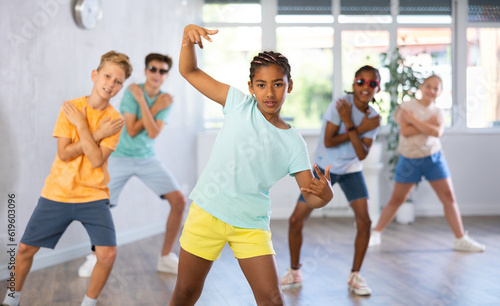 Happy boys and girls enjoying active dance in studio