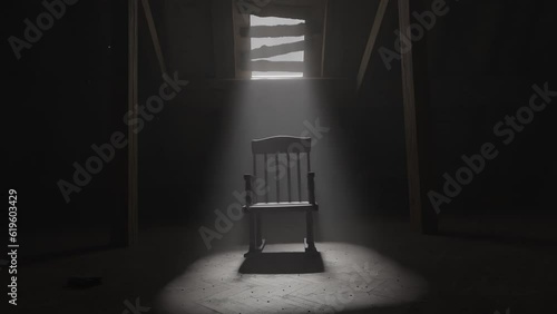 old rocking chair illuminated by light ray at dark attic. Concept age and past