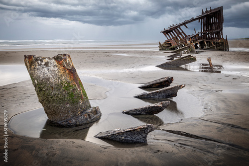 Foto Rusted old shipwreck on sandy beach