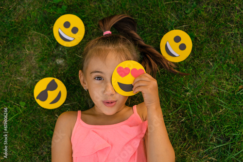 Canvas Print A surprised beautiful sweet girl closes her eye with a small emoji with hearts