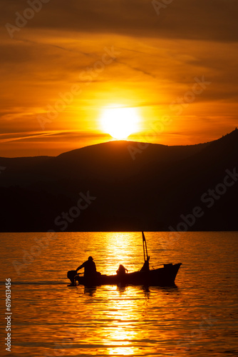 Silhouetted fishing boat at sunset - Sveti Stefan, Montenegro