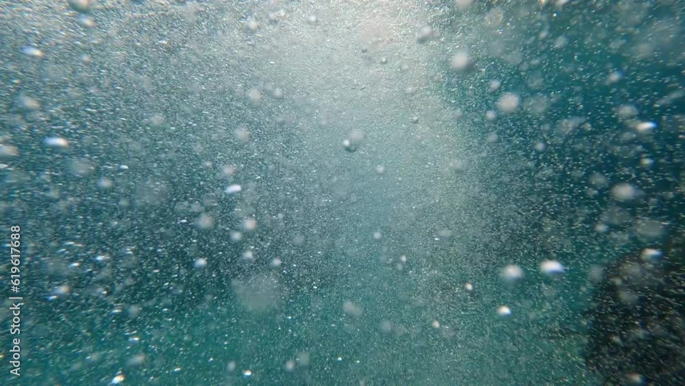 Underwater air Bubbles with sunlight through water surface, natural slow motion under water scene. Air bubbles floating from the sea bottom up to water surface Underwater air Bubbles with sunlight through water surface, natural slow motion under water scene. Air bubbles floating from the sea bottom up to water surface
