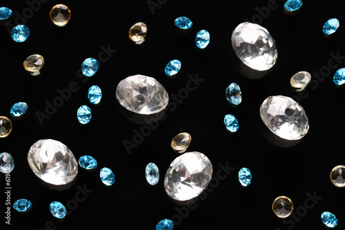 Different beautiful gemstones for jewelry on black background  flat lay