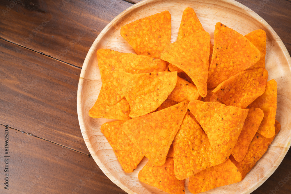 Crispy nachos in wooden plate on wooden background, Corn chips on wooden table. Crispy nachos in wooden plate on wooden background, Corn chips on wooden table.