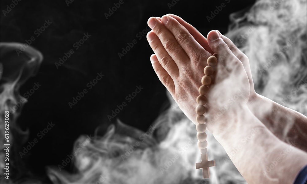 Muslim man hands praying with wood rosary beads