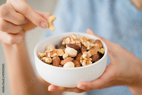 ミックスナッツを食べる若い女性 飲食イメージ