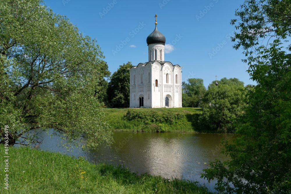 View of the Church of the Intercession on the Nerl on the shore of Floodplain Lake on a sunny summer day, Bogolyubovo village, Vladimir region, Russia